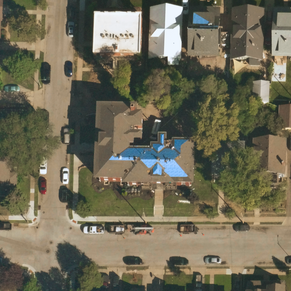 Near Space Labs' 10 cm capture of a property in a suburban area showcasing a blue tarp across sections of it's roof, indicating roof damage.