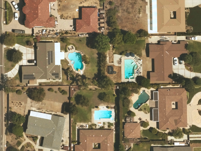 Near Space Labs' 10 cm capture of a residential neighborhood in California showing roofing details, swimming pools in the backyard, and surrounding foliage on each property. 